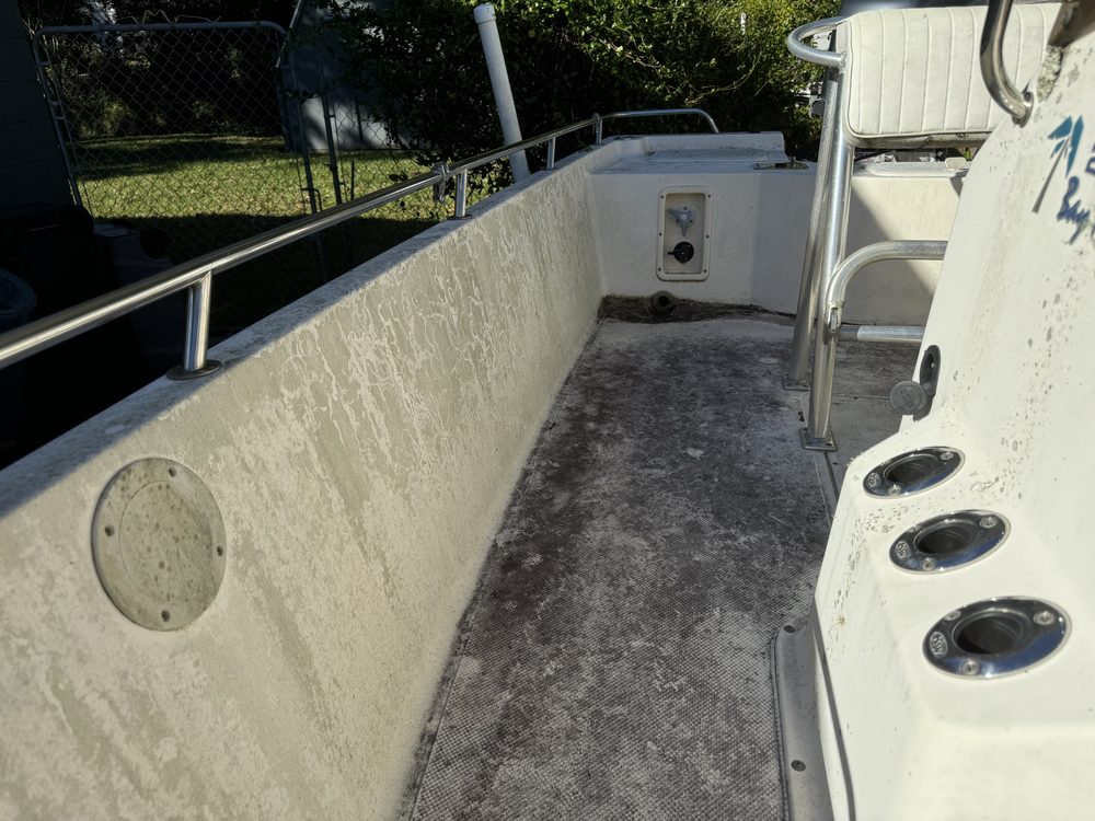 A bay boat gunwale and deck covered in mildew and grime